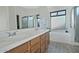 Double sink bathroom with wood cabinets and a bathtub at 18048 W Spencer Dr, Surprise, AZ 85374