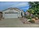 Single-story home with a two-car garage and landscaped front yard at 18048 W Spencer Dr, Surprise, AZ 85374