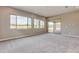 Bright bonus room with grey carpeting, large windows, and sliding glass door to patio at 29910 N Baker Ct, Scottsdale, AZ 85262