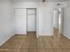Simple bedroom with mirrored closet doors and tile flooring at 3007 W Redfield Rd, Phoenix, AZ 85053