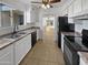 Kitchen with white cabinets, black appliances, and tile flooring at 3007 W Redfield Rd, Phoenix, AZ 85053