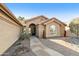 Tan stucco house with a tile roof, desert landscaping, and a stone walkway at 9521 E Rocky Lake Dr, Sun Lakes, AZ 85248