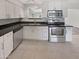 Modern kitchen with white cabinets, stainless steel appliances, and granite countertops at 1013 W Angela Dr, Phoenix, AZ 85023