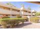 Light beige stucco building with red flowering bushes and a brick pathway at 1425 E Desert Cove Ave # 32, Phoenix, AZ 85020
