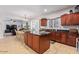 Modern kitchen with island, granite countertops, and wood cabinets at 30276 W Crittenden Ln, Buckeye, AZ 85396