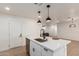 Modern kitchen island with stainless steel sink and white cabinets at 813 E Garnet Ave, Mesa, AZ 85204