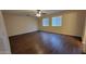 Well-lit bedroom with two windows and dark brown flooring at 9202 W Cambridge Ave, Phoenix, AZ 85037