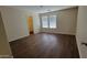 Bright bedroom with dark laminate flooring and a large closet at 9202 W Cambridge Ave, Phoenix, AZ 85037