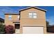 Tan two-story house with white garage door and landscaping at 9202 W Cambridge Ave, Phoenix, AZ 85037