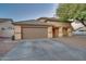 One-story home with a brown garage door and tree at 10776 W Encanto Blvd, Avondale, AZ 85392