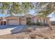 Single-story home with a tan facade, two-car garage, and landscaped yard at 13037 E Jenan Dr, Scottsdale, AZ 85259