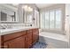 Bathroom with double vanity, soaking tub and window at 1321 W Clear Spring Dr, Gilbert, AZ 85233