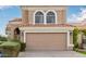Tan two-story house featuring arched windows and a two-car garage at 1321 W Clear Spring Dr, Gilbert, AZ 85233