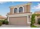 Two-story house with tan exterior, arched windows, and a two-car garage at 1321 W Clear Spring Dr, Gilbert, AZ 85233