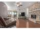 Living room with hardwood floors, stone fireplace, and a large TV at 1321 W Clear Spring Dr, Gilbert, AZ 85233