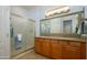Bathroom with double vanity, granite countertop, and shower at 13414 W Micheltorena Dr, Sun City West, AZ 85375