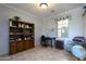 Home office with built-in shelving, desk, and comfortable armchair at 13414 W Micheltorena Dr, Sun City West, AZ 85375