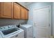 Laundry room with washer, dryer, and upper cabinets at 13414 W Micheltorena Dr, Sun City West, AZ 85375
