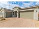 Two-car garage with paver driveway and neutral tones at 14196 W Gray Fox Trl, Surprise, AZ 85387