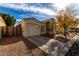 Tan house with a two-car garage and a gravel driveway at 143 N Drexel St, Mesa, AZ 85207