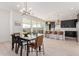 Kitchen and dining area with dark cabinetry, wood flooring, and modern chandelier at 17329 W Gretna St, Surprise, AZ 85388