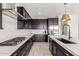 Modern kitchen with dark cabinetry, white countertops, and stainless steel appliances at 17329 W Gretna St, Surprise, AZ 85388