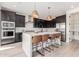 Modern kitchen with white island, dark cabinetry, and breakfast bar at 17329 W Gretna St, Surprise, AZ 85388