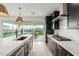 Modern kitchen features dark cabinetry, white quartz countertops, and a view of the backyard at 17329 W Gretna St, Surprise, AZ 85388