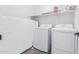 Bright laundry room with washer, dryer, and ample shelf space at 17329 W Gretna St, Surprise, AZ 85388