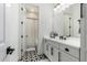 Clean bathroom with white cabinets and geometric floor tiles at 17662 W Whitefish Dr, Surprise, AZ 85388