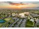 Aerial view of community at sunset with lake and amenities at 42906 W Darter Dr, Maricopa, AZ 85138