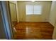 Bedroom with wood flooring, a mirror, and a window with blinds at 4901 S Calle Los Cerros Dr # 202, Tempe, AZ 85282