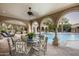 Relaxing covered patio with a dining table overlooking the pool at 6161 N 59Th Pl, Paradise Valley, AZ 85253