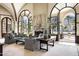 Living room with fireplace, large windows showcasing pool views, and comfortable sofas at 6161 N 59Th Pl, Paradise Valley, AZ 85253