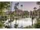 Serene pond with a fountain, lush landscaping, and arched stone features at 6161 N 59Th Pl, Paradise Valley, AZ 85253