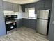 Updated kitchen with gray cabinets, stainless appliances, and wood-look flooring at 9623 E Baywood Ave, Mesa, AZ 85208