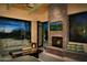 Relaxing living room with stone fireplace and view of the backyard at 11271 E Cinder Cone Trl, Scottsdale, AZ 85262