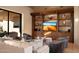 Sophisticated living area with built-in shelving and a large TV at 11271 E Cinder Cone Trl, Scottsdale, AZ 85262