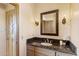 Elegant bathroom with granite countertop, updated vanity, and decorative mirror at 36849 N Stardust Ln, Carefree, AZ 85377