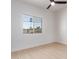 Bedroom with light wood floors, ceiling fan, and window with backyard view at 3753 E Paradise Dr, Phoenix, AZ 85028