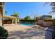 Spacious backyard with a refreshing pool, covered patio, and lush greenery at 4047 E Rowel Rd, Phoenix, AZ 85050