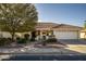 White one-story home with terracotta roof, landscaped yard, and two-car garage at 7739 E Navarro Ave, Mesa, AZ 85209