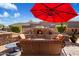 Relaxing patio with fireplace, seating area, and red umbrella at 7979 E Evening Glow Dr, Scottsdale, AZ 85266