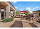 Outdoor patio with seating area, built-in barbecue and red umbrella at 7979 E Evening Glow Dr, Scottsdale, AZ 85266