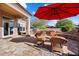 Spacious patio with seating area, outdoor kitchen, and red umbrella at 7979 E Evening Glow Dr, Scottsdale, AZ 85266