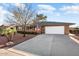 Ranch-style home with a spacious driveway and mature trees at 9843 W Cedar Dr, Sun City, AZ 85351