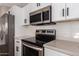 Modern kitchen with stainless steel appliances and white shaker cabinets at 1217 W Elna Rae St, Tempe, AZ 85281