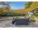 Relaxing backyard patio with seating area under shade sail at 1251 W Rancho Dr, Phoenix, AZ 85013