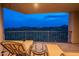 Evening view from a balcony with lounge chairs and a glass-top table, overlooking desert landscape at 14850 E Grandview Dr # 242, Fountain Hills, AZ 85268