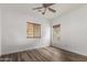 Bright bedroom with wood-look flooring, ceiling fan, and window blinds at 19668 E Carriage Way, Queen Creek, AZ 85142